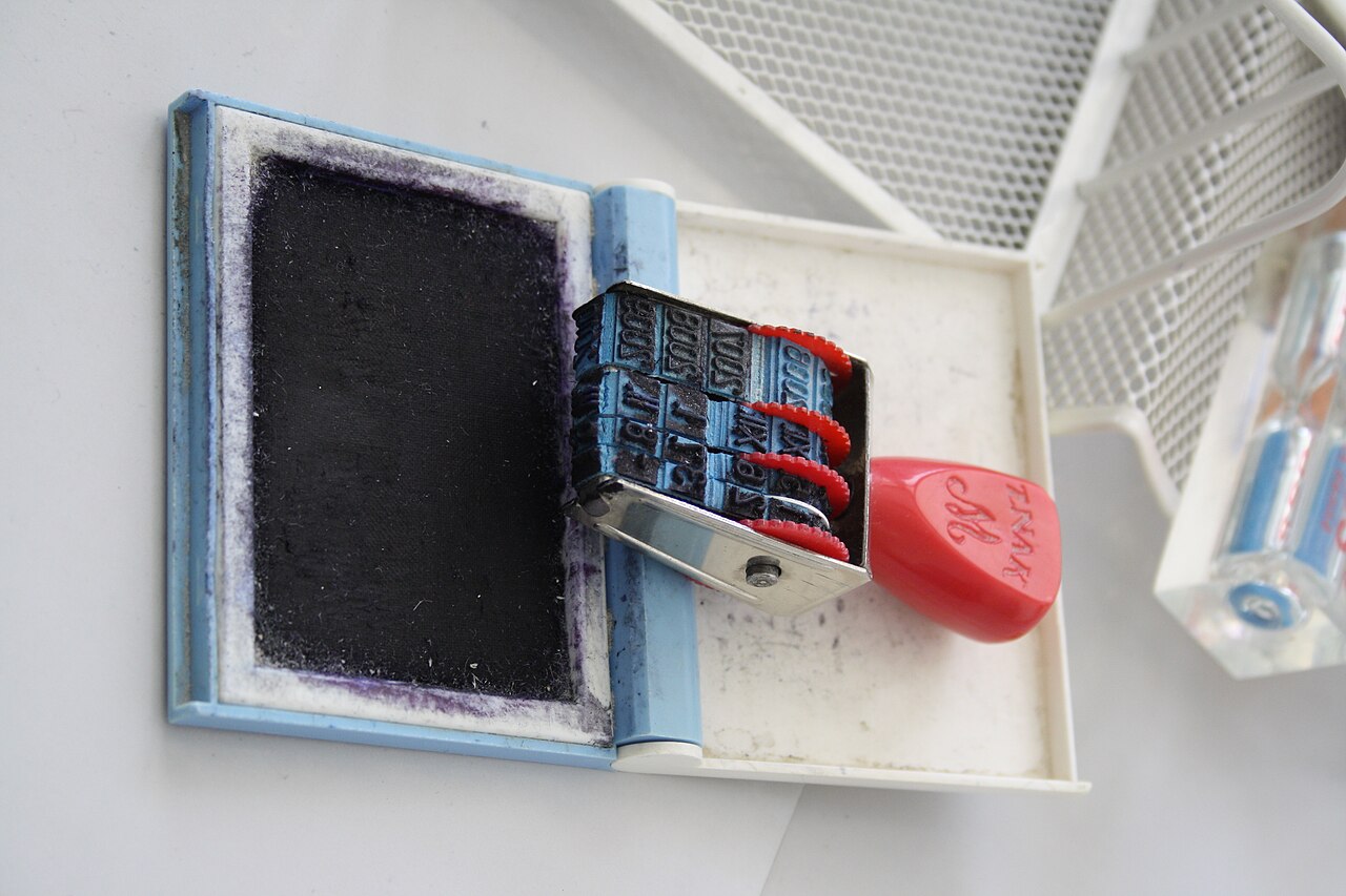 Office date stamp resting on an ink pad