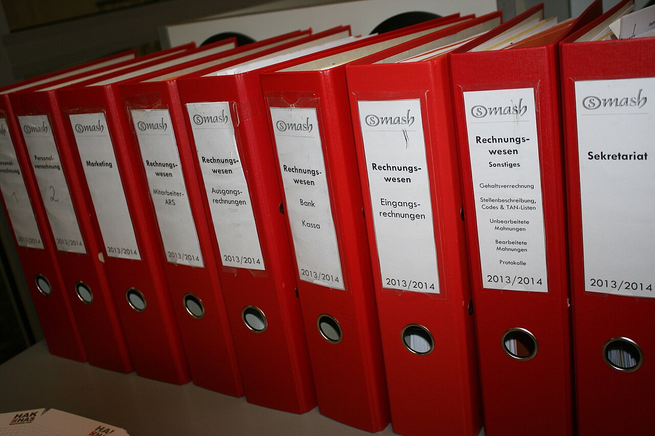 Row of red lever-arch accounting files on a shelf