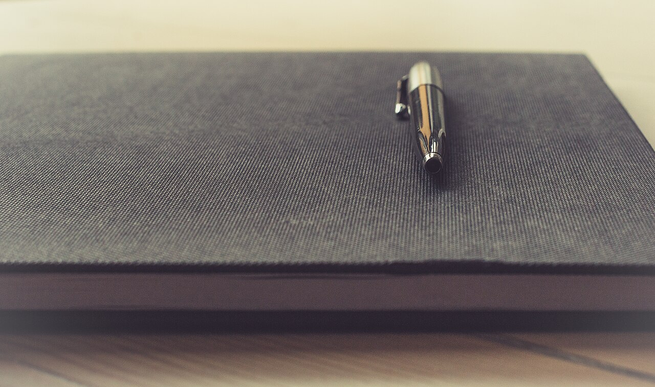 Pen on a notebook (Unsplash)