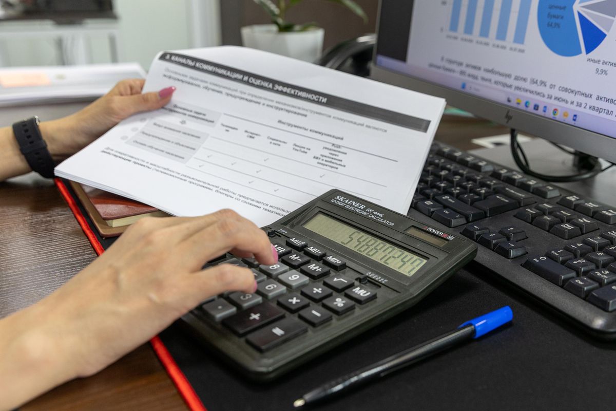 Person calculating figures from a business document