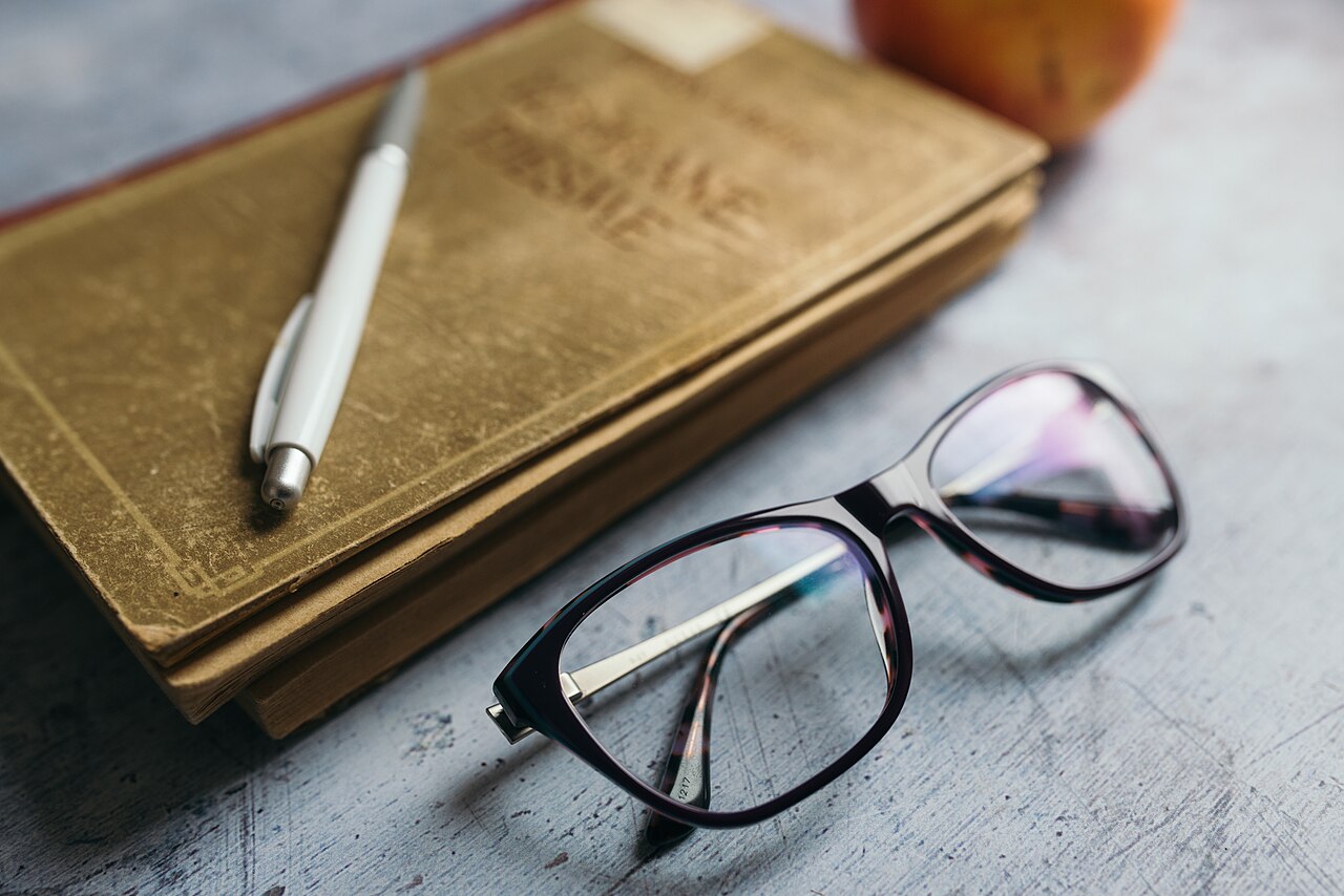 Notebook, pen and glasses on a desk